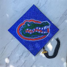 a blue graduation cap with the university of florida gators logo on it sitting on top of a white marble surface