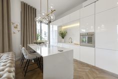 a modern kitchen with white cabinets and marble counter tops