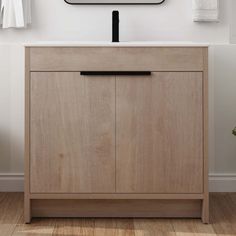 a bathroom vanity with a clock above it and towels hanging on the wall behind it