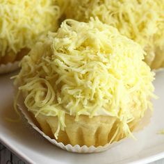 three cupcakes covered in cheese on a white plate