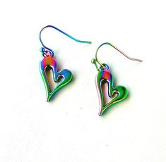 Elevate your accessory collection with our charming Small Heart Shaped Earrings Dangle, a perfect expression of affection. 🔸 Heart drop earrings length: approx. 1.5 x 0.6 inch = 3.8 x 1,5cm 🔸 Laser cut titanium rainbow heart earrings perfectly fashionable to complete any colourful outfit. 🧡 Crafted with care, these heart-shaped earrings showcase a mesmerizing rainbow titanium finish, creating an iridescent effect that's truly eye-catching. Hypoallergenic materials ensure comfortable wear for Cheap Multicolor Heart Dangle Earrings, Cheap Cute Multicolor Heart Earrings, Cheap Multicolor Heart Charm Earrings, Cheap Multicolor Dangle Heart Earrings, Cheap Rainbow Heart-shaped Jewelry, Titanium Earrings, Heart Shaped Earrings, Heart Drop Earrings, Rainbow Heart