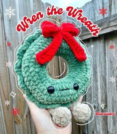 someone holding up a crocheted christmas wreath