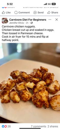 a white plate topped with fried food on top of a wooden table