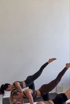 three women are doing yoga on their stomachs and legs, while one woman is holding her leg up in the air