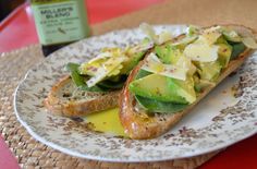 an open faced sandwich with lettuce and cheese on it sitting on a plate