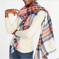 a woman wearing a white sweater and plaid scarf