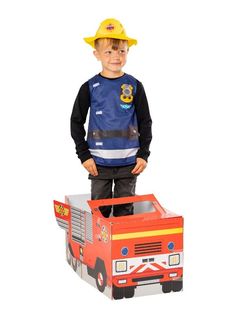 a young boy wearing a fireman's hat and holding a cardboard toy truck