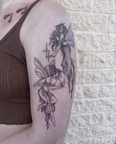 a woman with a tattoo on her arm holding onto a cross and a cupid