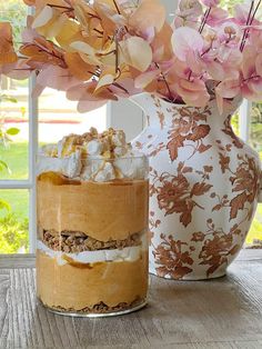 two vases filled with flowers on top of a wooden table next to each other