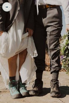 a bride and groom walking down the street together with their shoes on, holding each other's hands