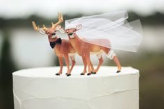 two deer figurines on top of a wedding cake