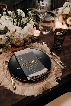 the table is set with white flowers and gold place settings for an elegant dinner party