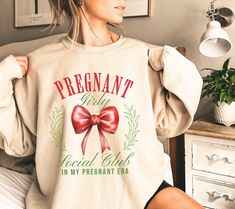 Subscribe and Save for exclusive discounts on our email list! Copy and paste this link into your browser: https://bit.ly/zandiscornerVIPCLUB Celebrate the joy of the season with our Christmas Pregnancy Announcement Shirt! Perfect for couples' Christmas pajamas, this festive maternity shirt is an adorable way to reveal your pregnancy. Whether it's a baby reveal Christmas surprise or a holiday gift for an expecting mom, this cozy sweatshirt will make the announcement unforgettable. Matching couples tees, maternity clothes, and funny baby shower gifts--this pregnancy reveal shirt has it all. Get ready to spread the holiday cheer with a new baby announcement that will delight everyone, from new grandparents to friends! For a more generously oversized appearance, we recommend sizing up by 1 siz Santa Baby Pregnancy Announcement, Christmas Pregnancy Shirts, Pregnant Christmas Shirts, Merry And Pregnant Sweatshirt, Christmas Pregnancy Announcement Shirt, Christmas Maternity, Pregnant Mom Gifts, Funny Baby Shower Gifts, Pregnancy Reveal Shirt