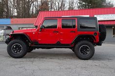 a red jeep parked in front of a building