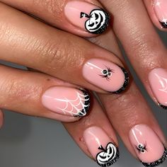 a woman's hands with pink and black nail designs on their nails, holding a spider web manicure