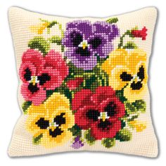 a cross stitch pillow with colorful flowers on the front and back of it's cushion