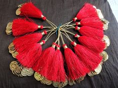 a bunch of red tassels sitting on top of a black cloth covered table