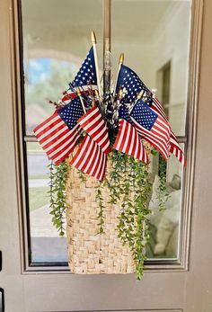 a basket filled with american flags hanging from the side of a door