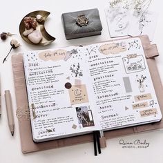 an open planner with various items on it and some writing utensils next to it