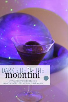 a purple drink in a martini glass with the words dark side of the moon on it