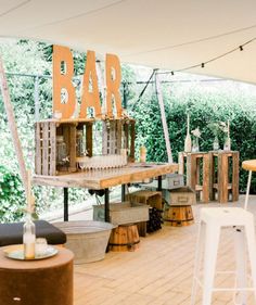 an outdoor bar set up with stools and tables