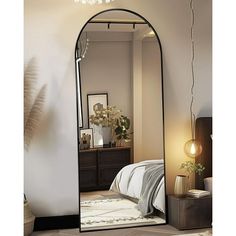 a large mirror sitting on top of a floor next to a bed