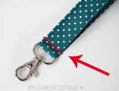 an apple green polka dot keychain with a red arrow pointing to it