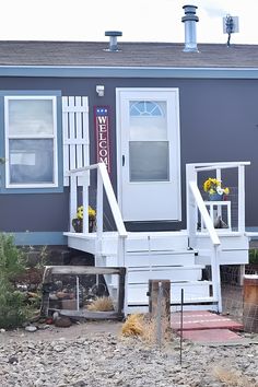 the front of a house with steps leading up to it's door and windows