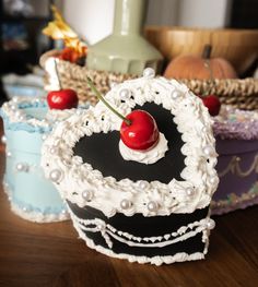 a heart shaped cake sitting on top of a wooden table next to two baskets filled with fruit