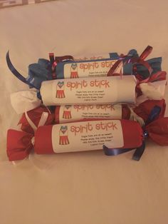 three rolls of red, white and blue ribbon wrapped in plastic on top of a bed