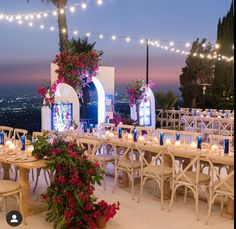 tables and chairs are set up for an outdoor event with lights strung over the top