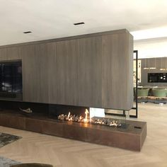 a living room filled with furniture and a fire place next to a tv mounted on a wall