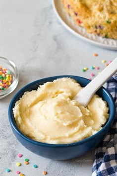 a blue bowl filled with mashed potatoes and sprinkles next to a plate