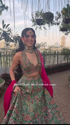 a woman in a green and pink lehenga