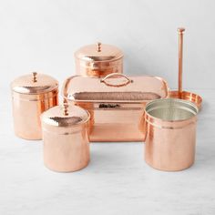 a set of copper colored pots and pans