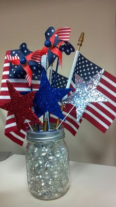 a mason jar filled with red, white and blue pinwheels