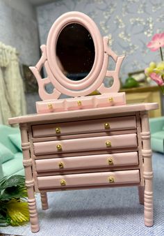 a pink dresser with a mirror on top of it