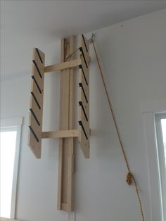 a piece of wood that is attached to a wall with ropes hanging from the ceiling