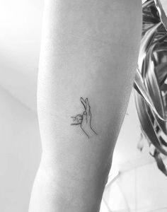 a woman's arm with a small tattoo on the left side of her arm