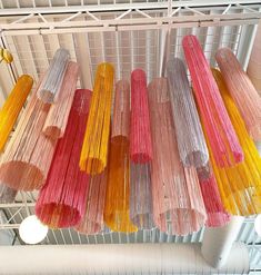 several different colored sticks hanging from a ceiling