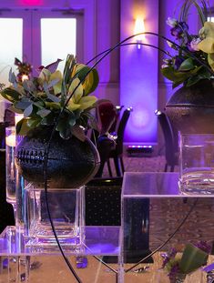 two vases filled with flowers sitting on top of a table next to each other