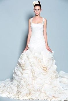 a woman in a white wedding dress with flowers on the skirt