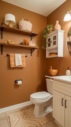 a white toilet sitting under a bathroom mirror next to a counter top with towels on it