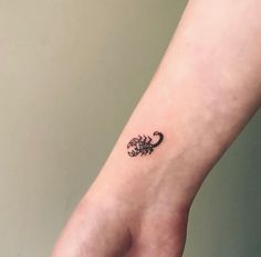 a small scorpion tattoo on the wrist