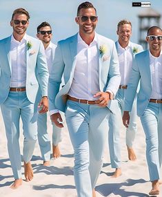 a group of men in suits and sunglasses walking on the beach with one man wearing shades