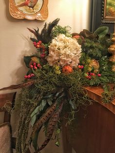 a bouquet of flowers sitting on top of a wooden table next to a framed painting