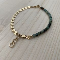 "This bracelet is super lightweight and delicate, but packs a big punch for being so petite. I love that it is a combo of smooth, subtle beads and bold, eye catching chain! The best of both worlds. Perfect for stacking up with other bracelets, or wearing alone. The high low bracelet is made from African turquoise beads, and either 14k gold fill or sterling silver coin chain and components. Since this is a handmade item, please allow for slight variations in your bracelet from those that you see Adjustable Bohemian Bracelet With Delicate Chain, Adjustable Dainty Green Chain Bracelet, Dainty Green Adjustable Chain Bracelet, Dainty Nickel-free 14k Gold-filled Bracelets, Dainty 14k Gold-filled Nickel-free Bracelet, Dainty 14k Gold Filled Nickel-free Bracelet, Gold Bohemian Hypoallergenic Bracelets, Green Bracelet With Adjustable Chain, Green Bracelets With Adjustable Chain