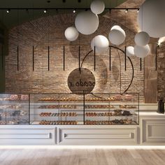 the interior of a bakery with lots of baked goods on display and lights hanging from the ceiling