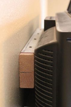 a black speaker sitting on top of a wooden shelf