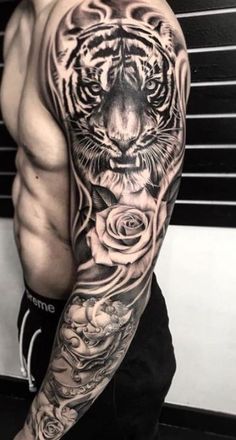 a man's arm with a tiger and roses tattoo on the left side of his arm